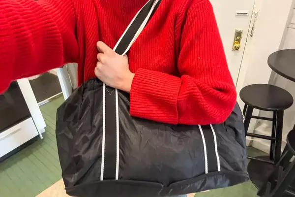 A person carries a Paravel Fold-Up Bag on their shoulder