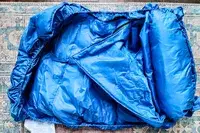 The sleeping bag for the Regalo My Cot Deluxe Portable Toddler Bed partially rolled up