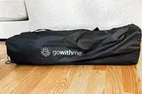 The Baby Delight Go With Me Bungalow Deluxe Portable Travel Cot folded up inside a branded storage bag