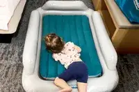 A child lies on the SlumberPod Slumber Tot Inflatable Toddler Bed