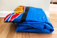 The Funboy Kids Sleepover Air Mattress folded up on a wooden floor