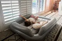 A child lies on the SlumberPod Slumber Tot Inflatable Toddler Bed