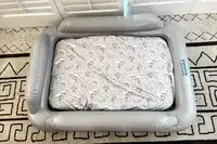 The fully inflated SlumberPod Slumber Tot Inflatable Toddler Bed on a colorful rug