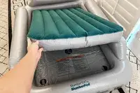 A person places an inflatable mattress into the SlumberPod Slumber Tot Inflatable Toddler Bed