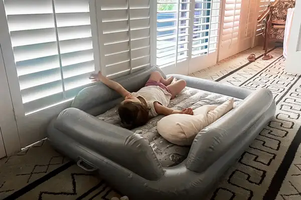 A child lies on the SlumberPod Slumber Tot Inflatable Toddler Bed