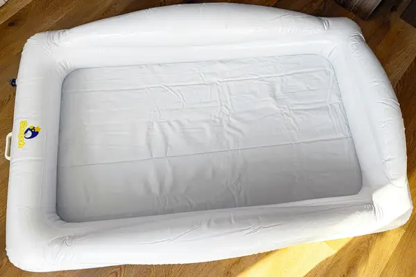 The Sleepah Inflatable Toddler Travel Bed on a wooden floor