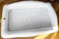 The Sleepah Inflatable Toddler Travel Bed on a wooden floor