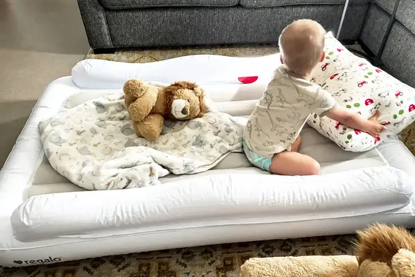 A child sits in the Regalo Inflatable Toddler Bed