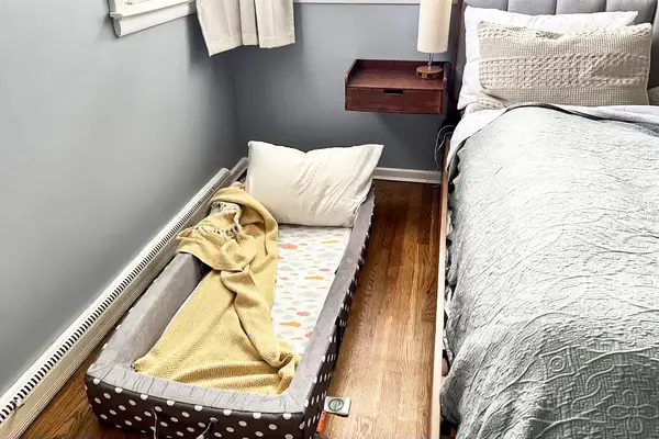 The Milliard Portable Toddler Folding Floor Mat next to a larger mattress