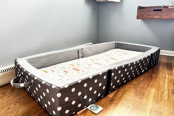 The Milliard Portable Toddler Folding Floor Mat in the corner of a room