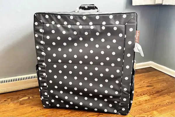 The Milliard Portable Toddler Folding Floor Mat folded up in the corner of a room