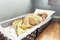 A child sleeps in the Milliard Portable Toddler Folding Floor Mat