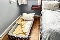 The Milliard Portable Toddler Folding Floor Mat next to a larger mattress