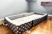 The Milliard Portable Toddler Folding Floor Mat in the corner of a room