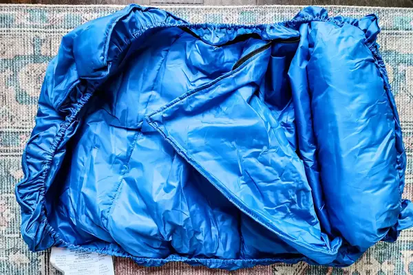 The sleeping bag for the Regalo My Cot Deluxe Portable Toddler Bed partially rolled up