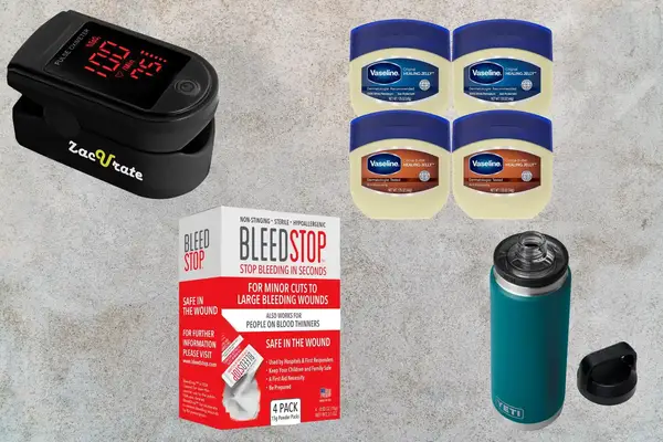 Various health and personal care products displayed on a surface including a pulse oximeter, petroleum jelly, wound dressing, and a thermos