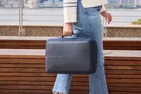 A person carries the XDDesign Bobby Bizz 3-in-1 Anti-Theft Backpack & Briefcase by a side handle