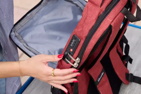 A person touches the lock on the SHRRADOO Anti Theft Laptop Backpack