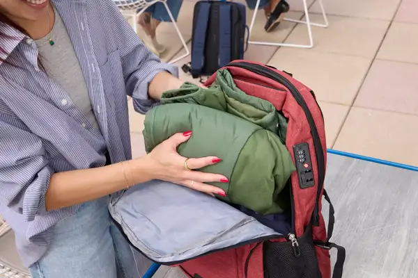 A person places a jacket into the SHRRADOO Anti Theft Laptop Backpack