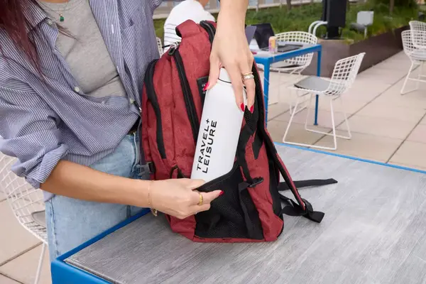 A person places a water bottle into the SHRRADOO Anti Theft Laptop Backpack