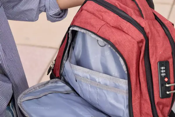 A person holds open the pocket on the SHRRADOO Anti Theft Laptop Backpack