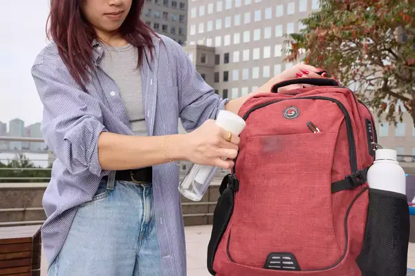 A person sprays the SHRRADOO Anti Theft Laptop Backpack with water