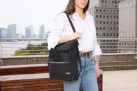 A person carries the Solo NY Stealth Hybrid Backpack by the shoulder strap