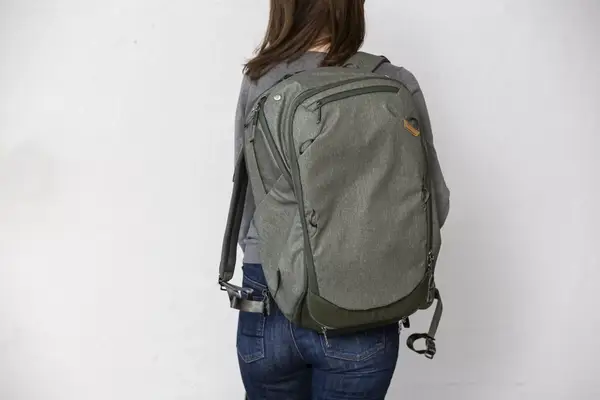 A person zips up the Solo NY Stealth Hybrid Backpack