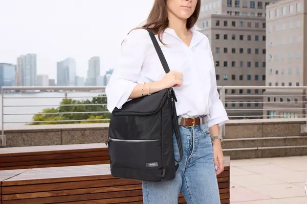 A person carries the Solo NY Stealth Hybrid Backpack by the shoulder strap