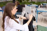 A person places a laptop into the Solo NY Stealth Hybrid Backpack