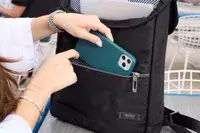 A person places a cell phone into the Solo NY Stealth Hybrid Backpack