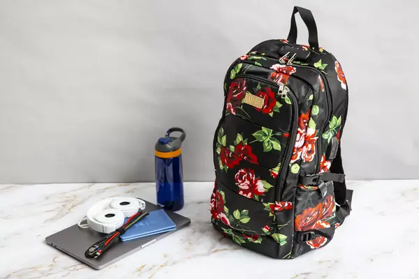 A person removes a wallet from the Baggallini Securtex Anti-Theft Vacation Backpack front pocket