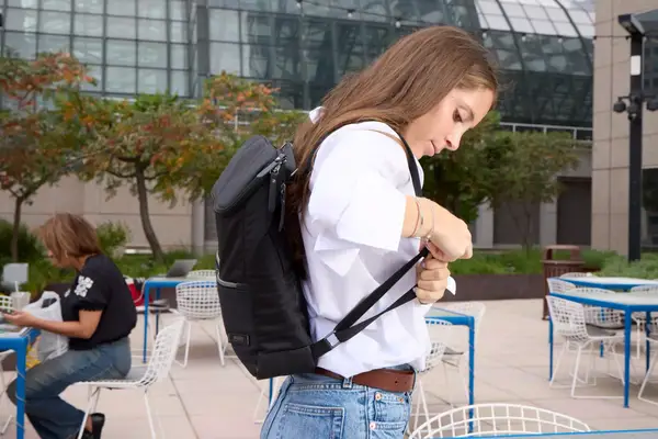 A person adjusts the Solo NY Stealth Hybrid Backpack