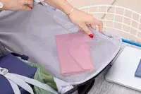 A person places a wallet into the Pacsafe Venturesafe EXP45 Anti-Theft Carry-On Travel Pack