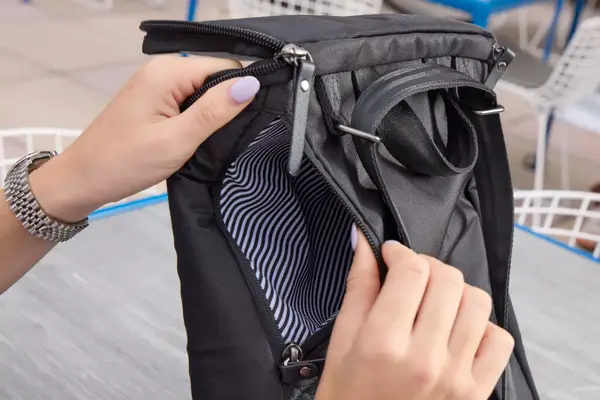 A person holds open the pocket on the Solo NY Stealth Hybrid Backpack