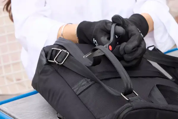 A person cuts the strap on the Solo NY Stealth Hybrid Backpack