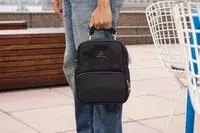 A person holds the Arden Cove Carmel Convertible Backpack and Crossbody by the top handle