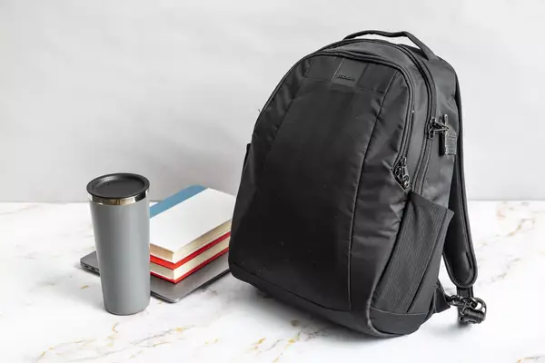 A person zips up the Solo NY Stealth Hybrid Backpack