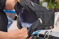 A person opens the Arden Cove Carmel Convertible Backpack and Crossbody