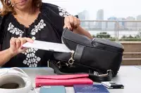 A person places a tablet into the Arden Cove Carmel Convertible Backpack and Crossbody
