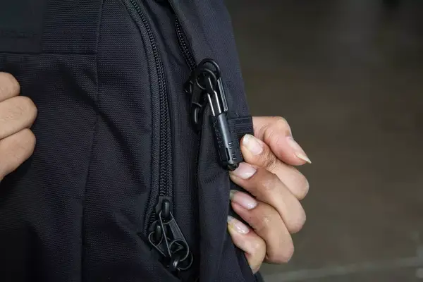 A person attaches a keychain to the Solo NY Stealth Hybrid Backpack