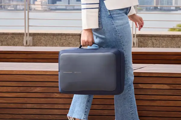 A person carries the XDDesign Bobby Bizz 3-in-1 Anti-Theft Backpack & Briefcase by a side handle