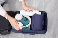 A person places travel items into the XDDesign Bobby Bizz 3-in-1 Anti-Theft Backpack & Briefcase