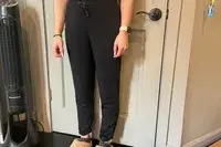 A person wears the Spanx AirEssentials Tapered Pant inside a house