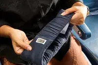 A person stretching the strap of the Lunya Washable Silk Sleep Mask