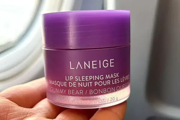 Person holding Laneige Sleep Mask on an airplane