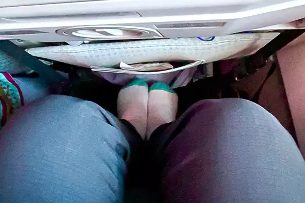 Person sitting on airplane with feet on foot rest