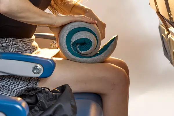 A person unrolling the Ostrich Pillow Go Neck Pillow