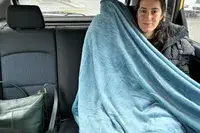 Person using the PAVILIA Travel Blanket and Pillow in the backseat of a car