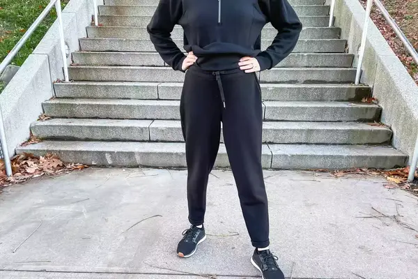 A person wearing the Spanx AirEssentials Tapered Pant outside in front of stairs